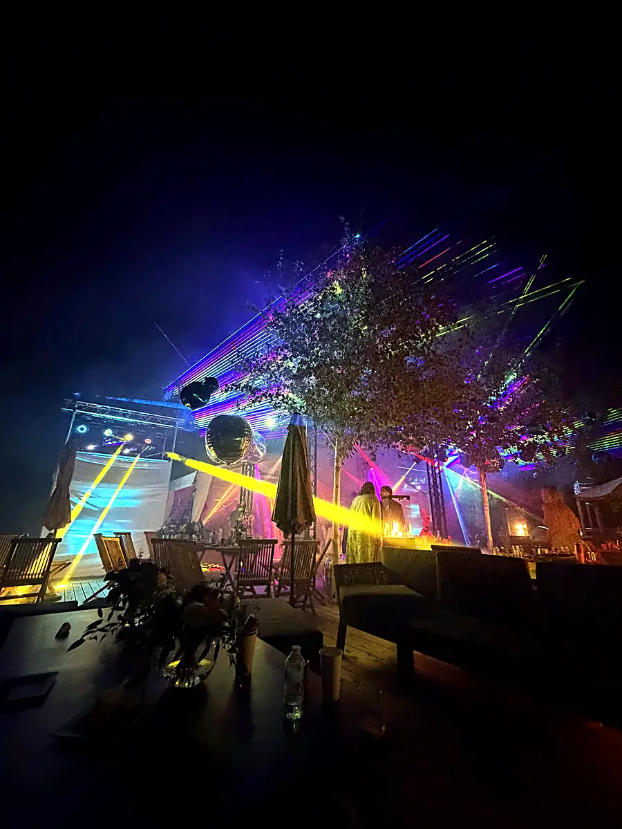 Yellow beams and lasers over an outdoor stage at night