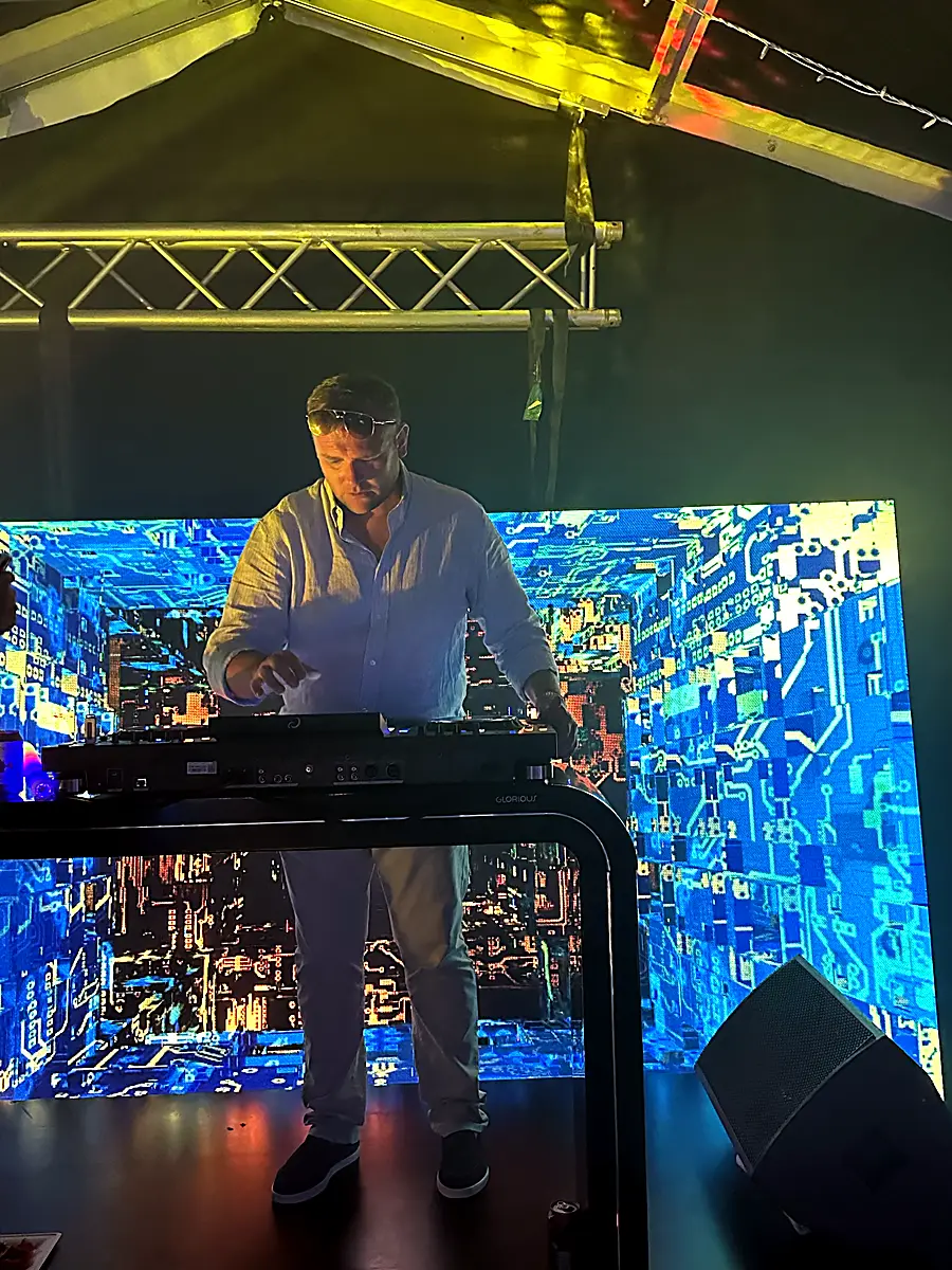 DJ playing in front of an LED wall rigged on our truss
